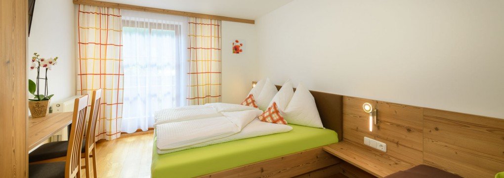 Doppelbett im hell möblierten Schlafzimmer im Appartement Hinterhub